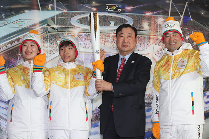 Lee Hee-beom (second from R), head of the organizing committee for the 2018 PyeongChang Winter Olympics holds up the Olympic torch unveiled on Feb. 9, 2017, at Gangneung Hockey Centre in Gangneung, Gangwon Province.